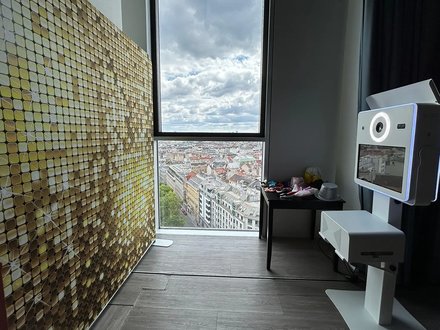 Fotobox Classic vor goldener Glitzerwand mit Panoramablick über Wien