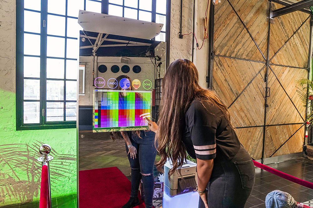 Zwei Gäste vor dem Magic Mirror X in einer Backsteinhalle