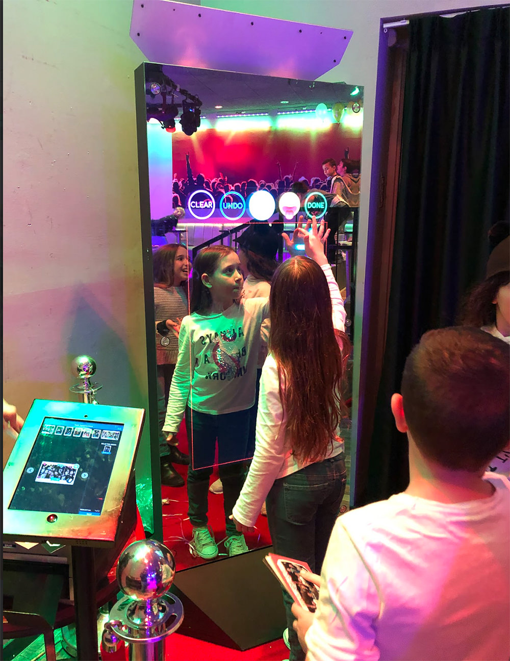 Kinder vor dem Magic Mirror X mit buntem Auswahlbildschirm