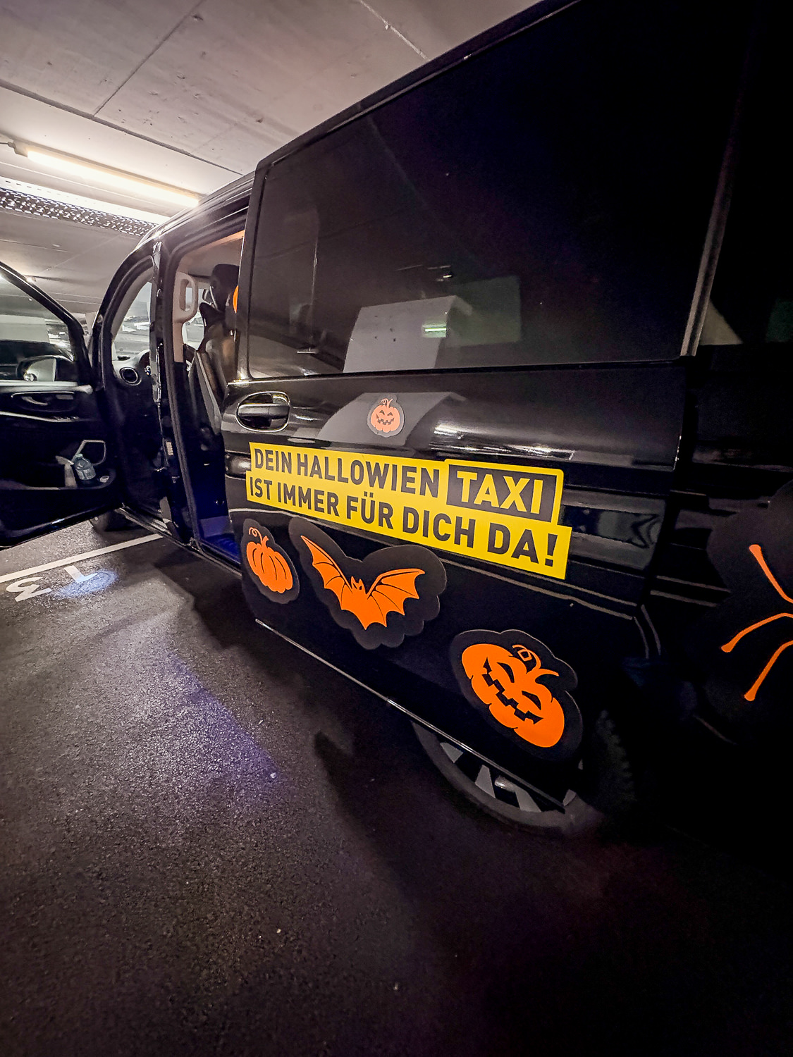 Halloween wrapped taxi with the sliding door open at night