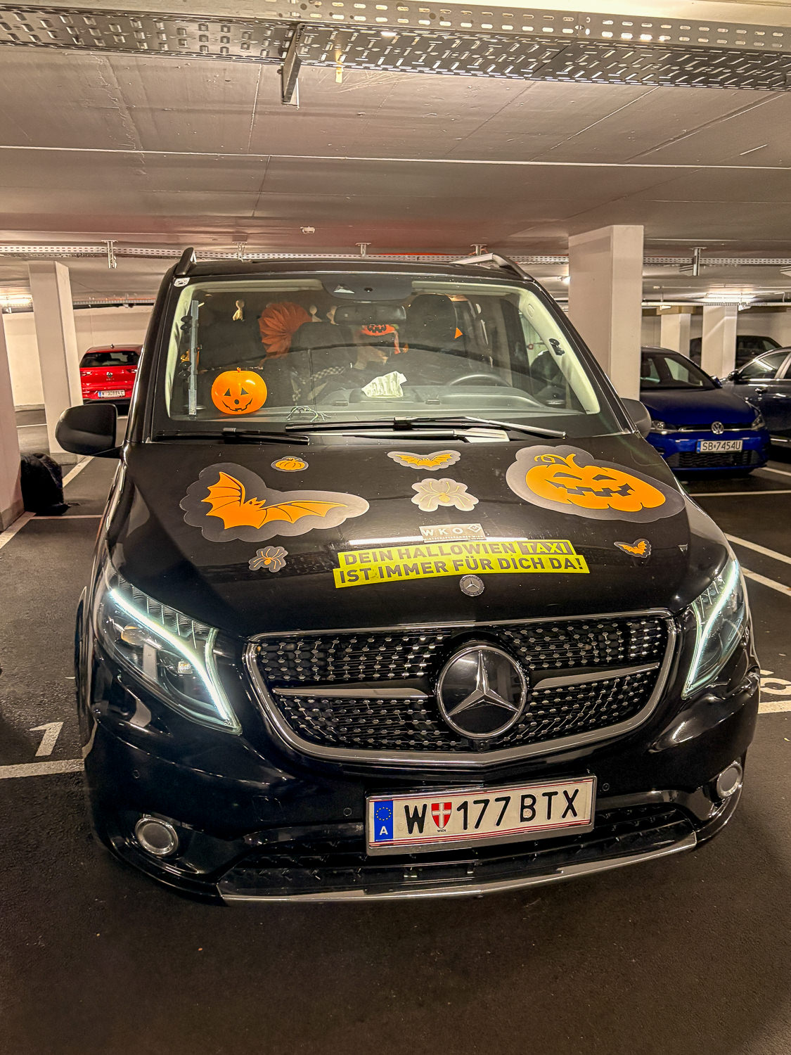 Black taxi with Halloween stickers in a garage