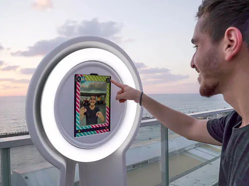 Gast tippt auf den Touchscreen des Videobooth auf einer Terrasse am Meer