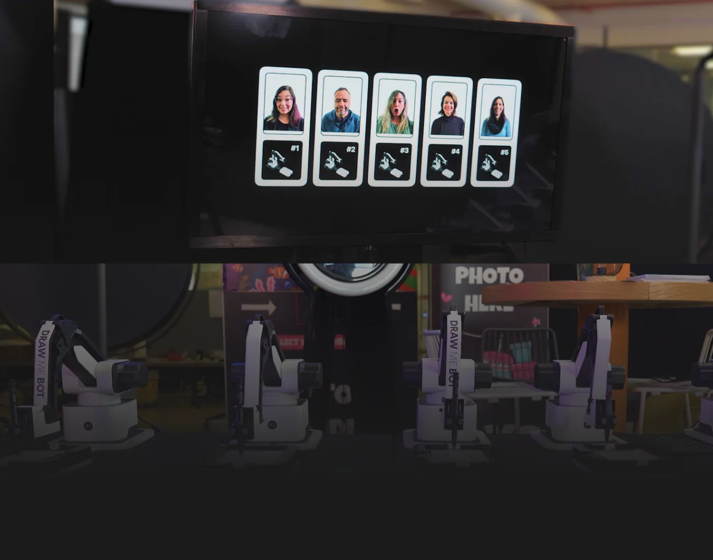 External monitor above the drawing robots showing the finished portraits