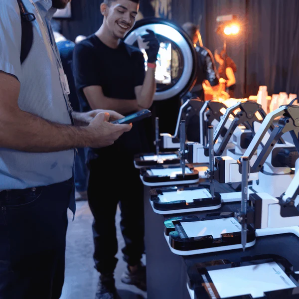 Guests watching the AI Sketcher robots draw at the event stand
