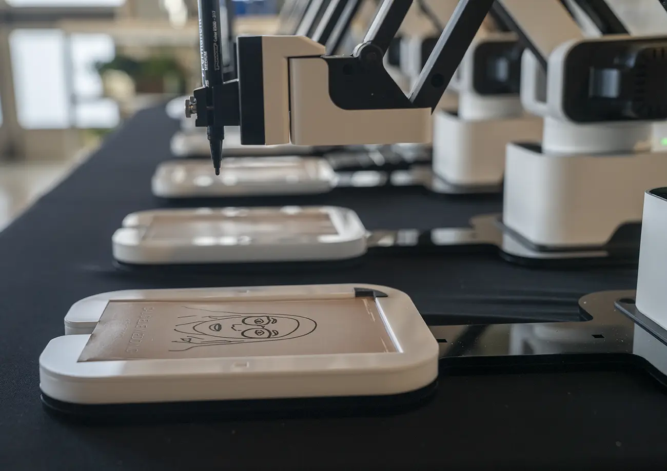 Close-up of the AI Sketcher robot arm drawing a portrait