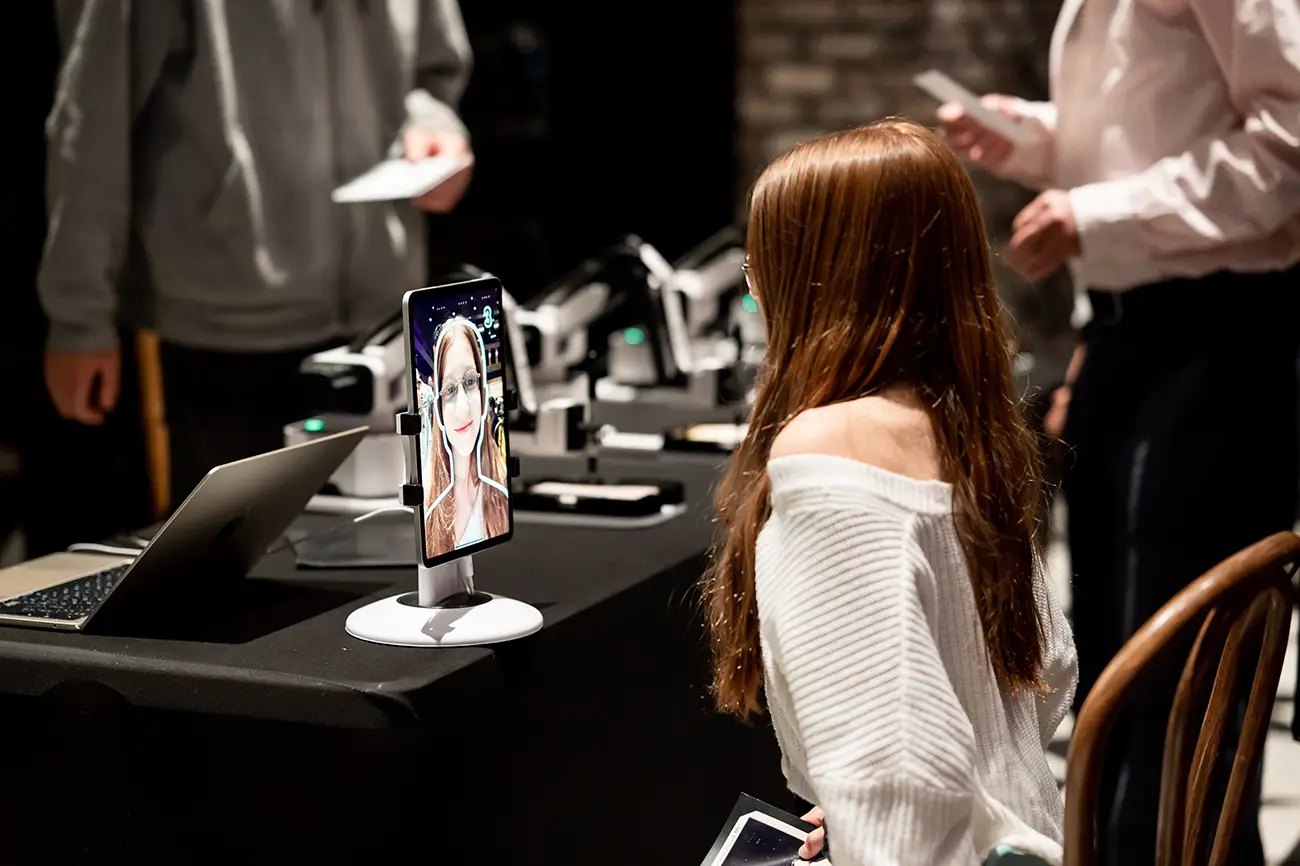 Guest looking at her portrait on the tablet at the robot stand