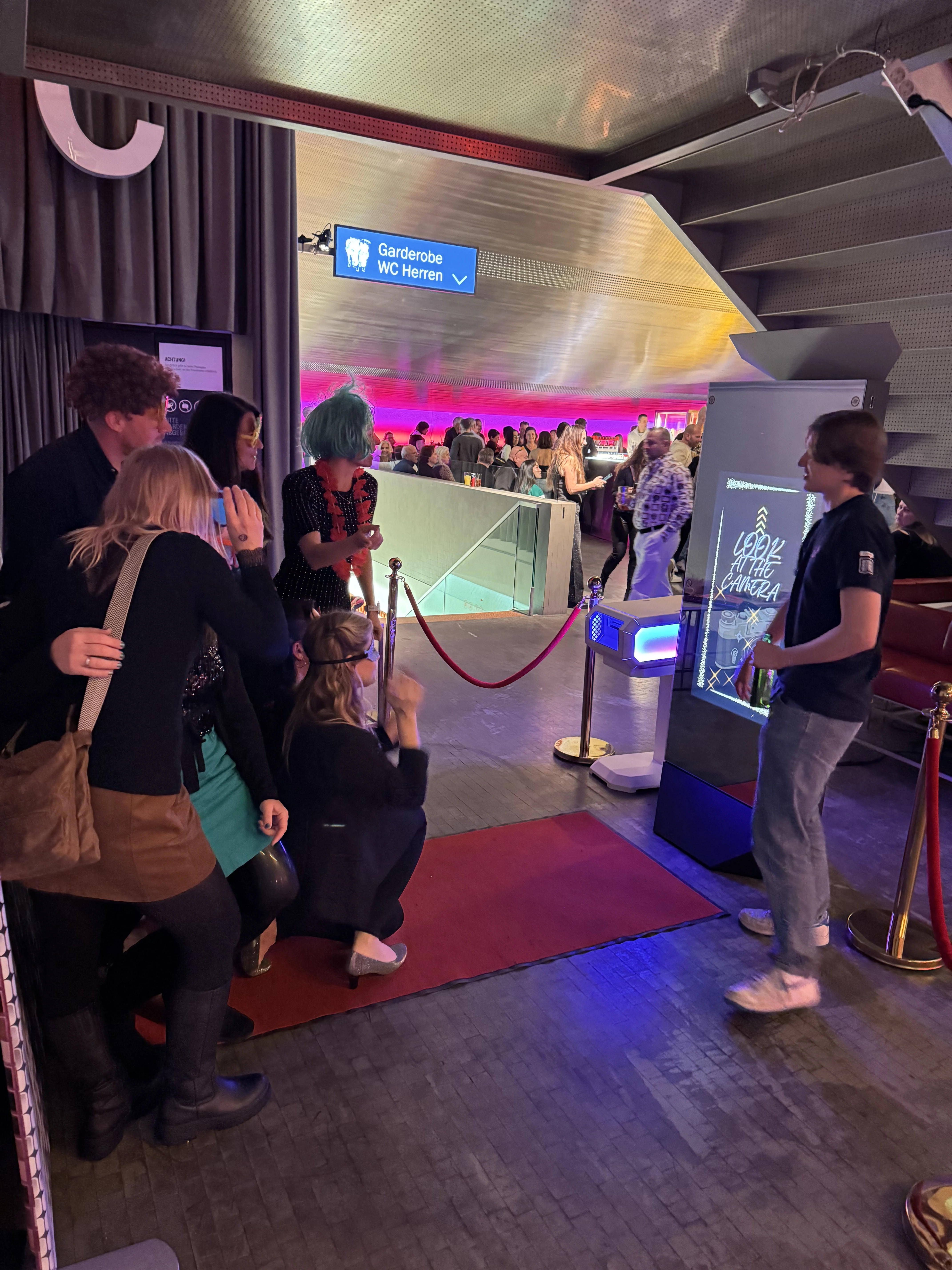 Guests waiting in front of the AI Magic Mirror in a foyer with a red carpet
