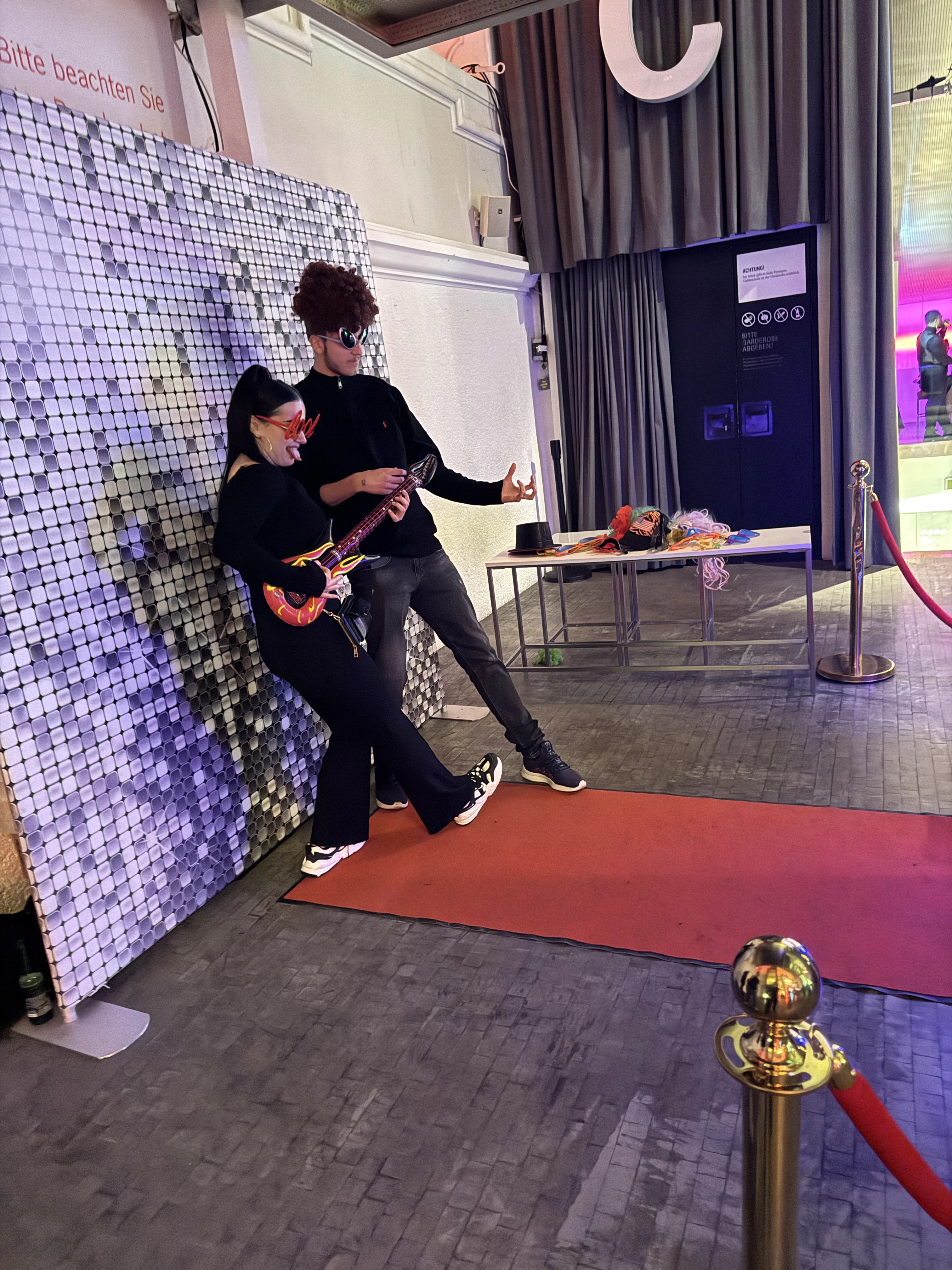 Guests posing in front of the sequin wall on the red carpet