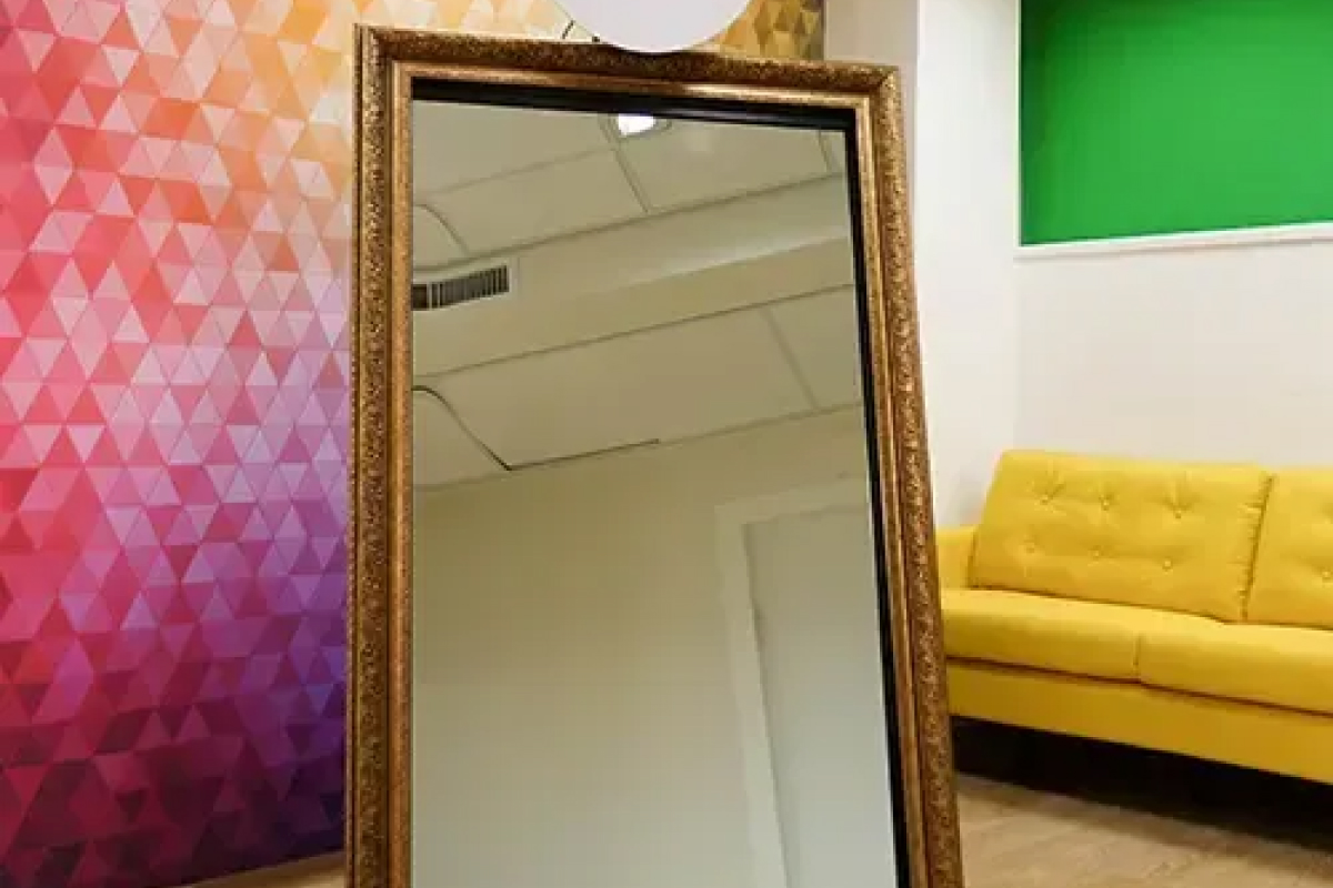 Magic Mirror Retro in a gold frame next to a yellow sofa