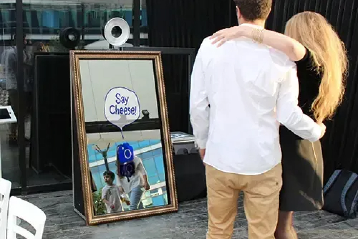 Couple posing in front of the Magic Mirror Retro with a say cheese animation