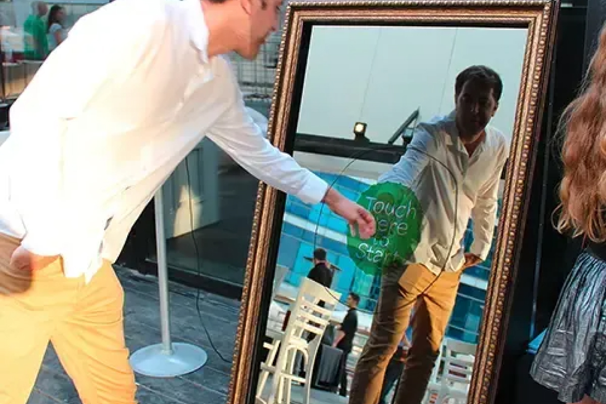 Guest tapping the Magic Mirror Retro at an outdoor event