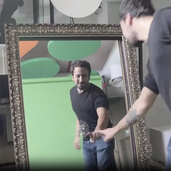 Staff member setting up the mirror photo booth with a green screen for the mosaic