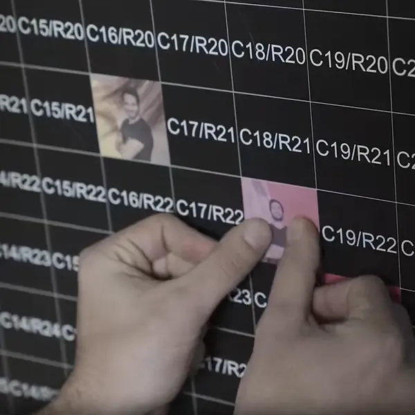 Guest sticking a photo sticker onto the coordinate grid of the mosaic wall