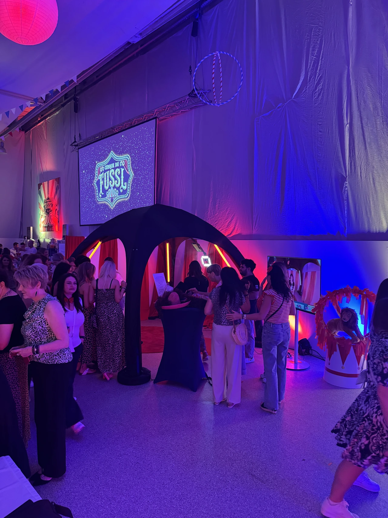 360° Videobooth in einem blau beleuchteten Saal voller Gäste