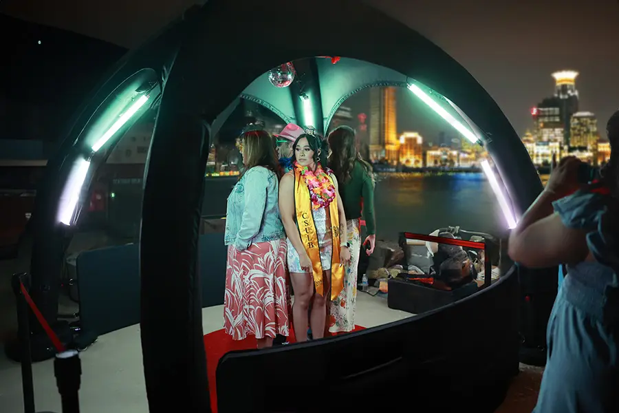 Gästinnen posieren im 360° Videobooth vor einer Stadtkulisse