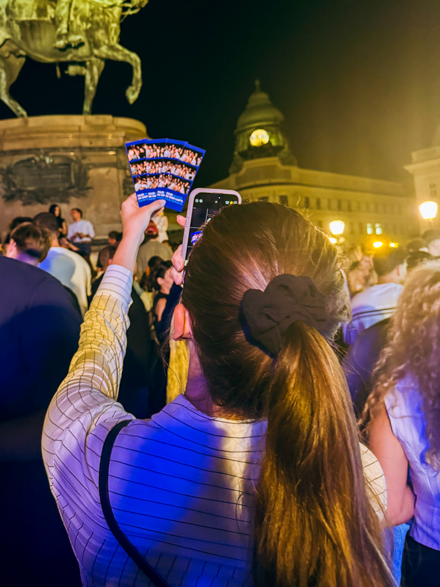 Guest holding up her photo print at night
