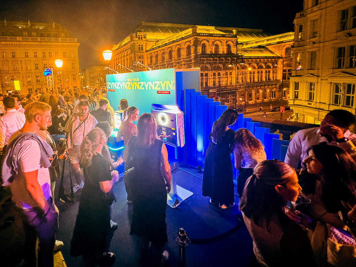 Guests at the blue lit stand at dusk