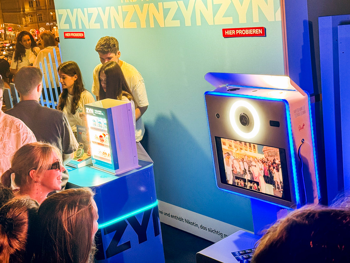 Guests at the blue branded photo booth of the open air stand
