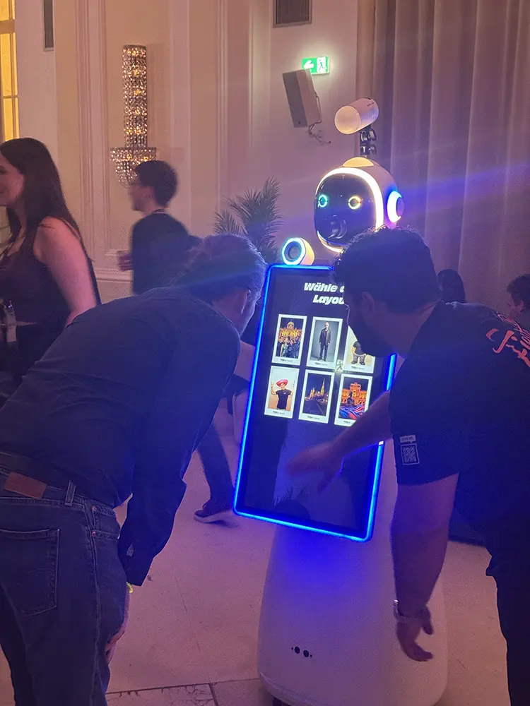 Zwei Gäste wählen am Bildschirm des Fotobox Roboters LUNA ihr Drucklayout
