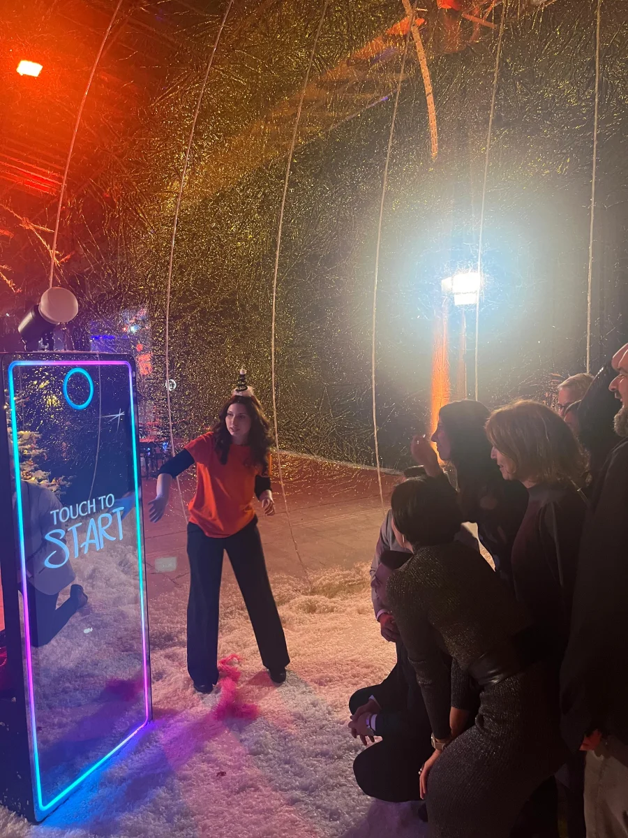 Gästin posiert vor dem AI Magic Tower, am Display steht Touch to Start