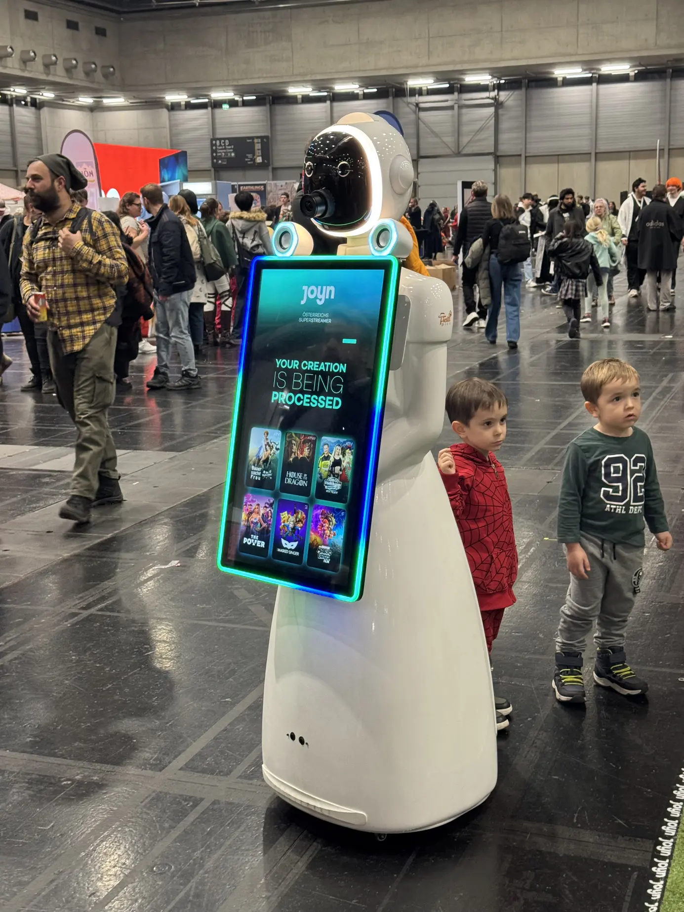 Zwei Kinder warten gespannt vor LUNAs Touchscreen, während ihr KI-Bild erstellt wird