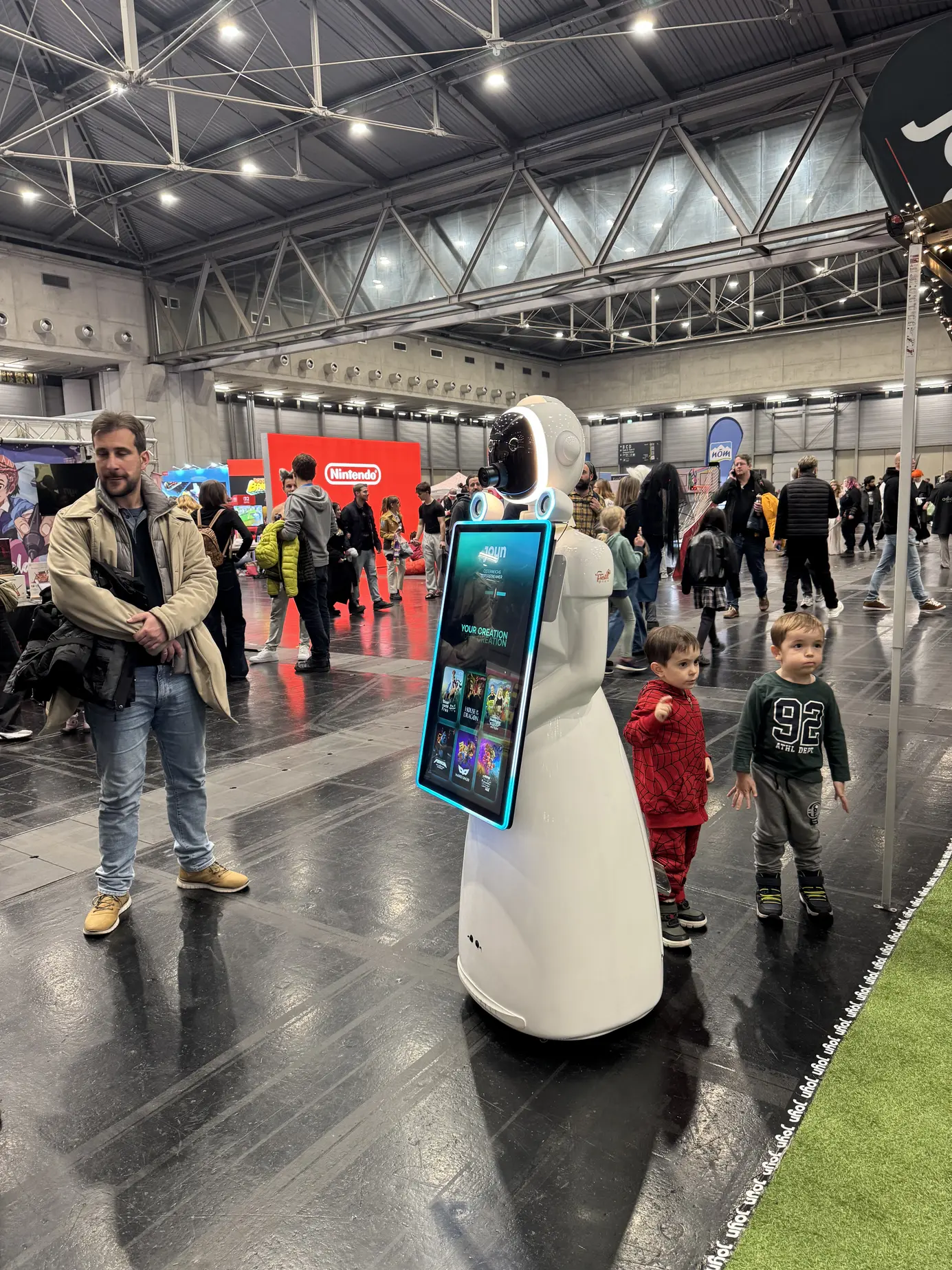 Kinder bestaunen den AI Fotobox Roboter LUNA in der Messehalle