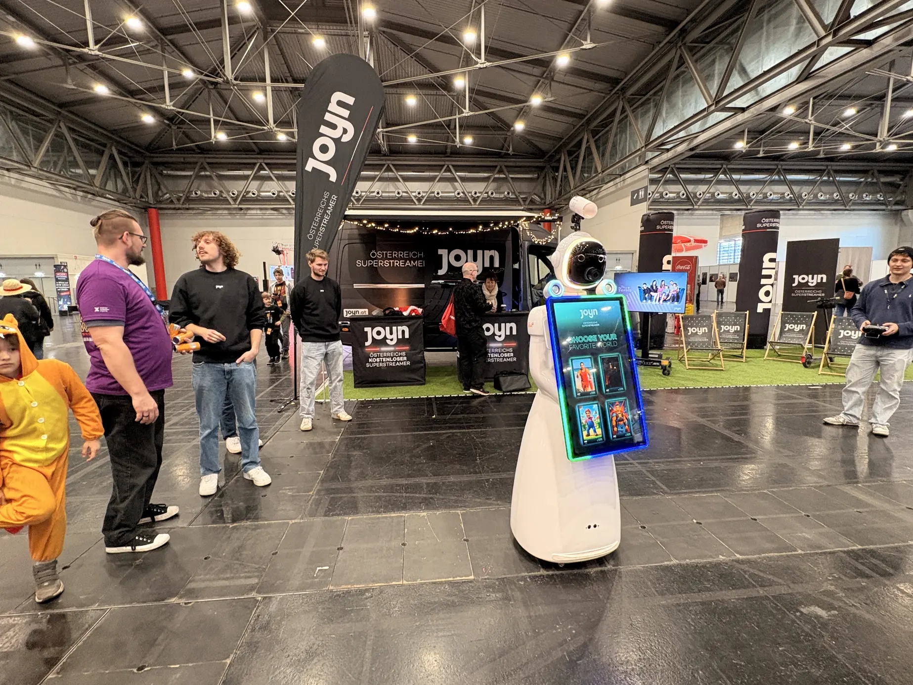 AI Fotobox Roboter LUNA von FiestaPics im Joyn-Branding vor dem Joyn-Stand bei der Vienna Comic Con 2025 in der Messe Wien