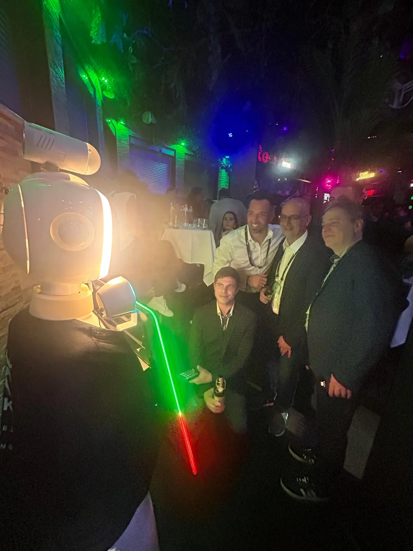 Gruppe von ELK-Gästen posiert im Laserlicht für ein Foto mit dem AI Roboter LUNA