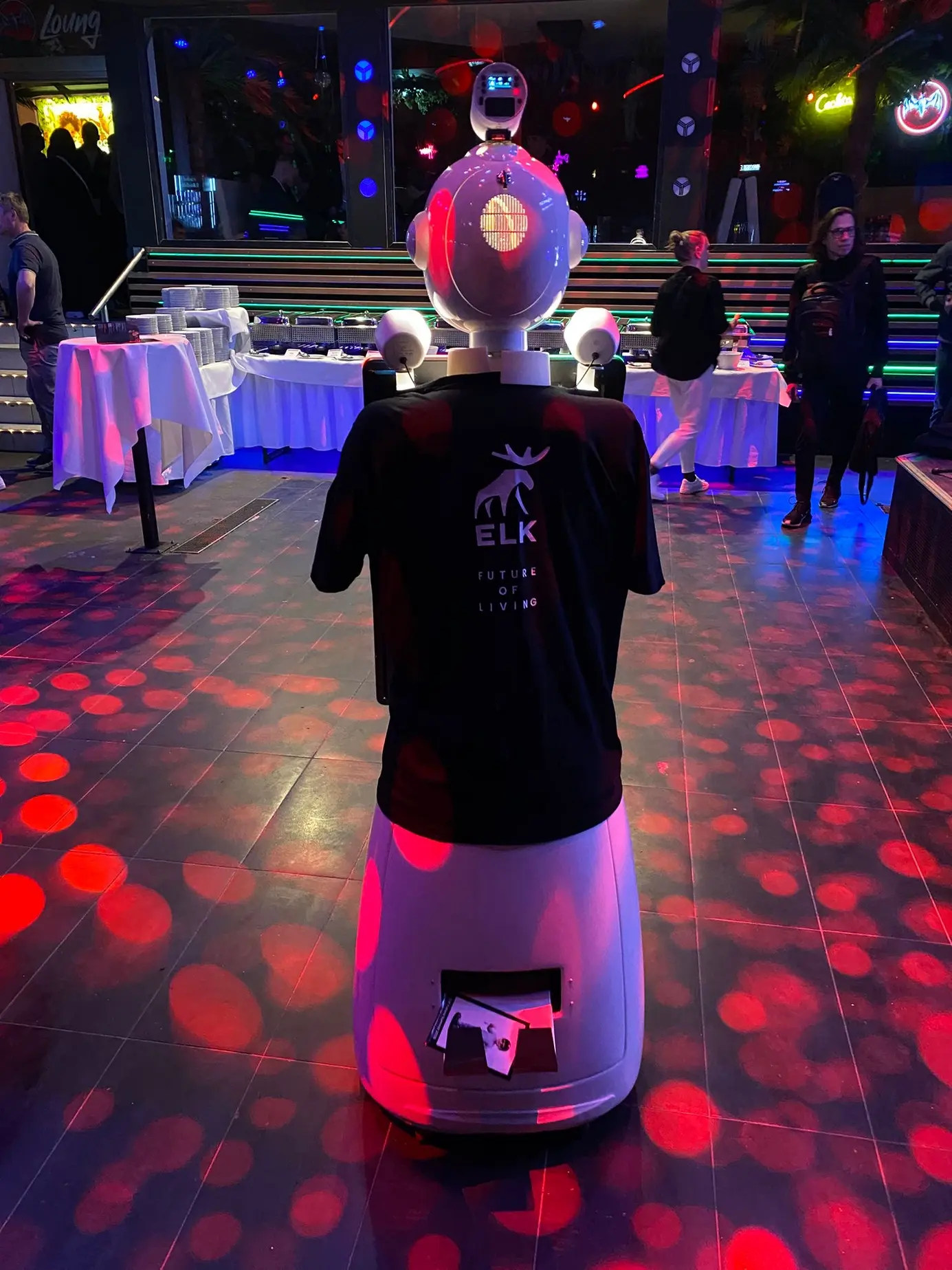 Der Roboter LUNA mit schwarzem ELK-Shirt auf der beleuchteten Tanzfläche der Discothek Ypsilon