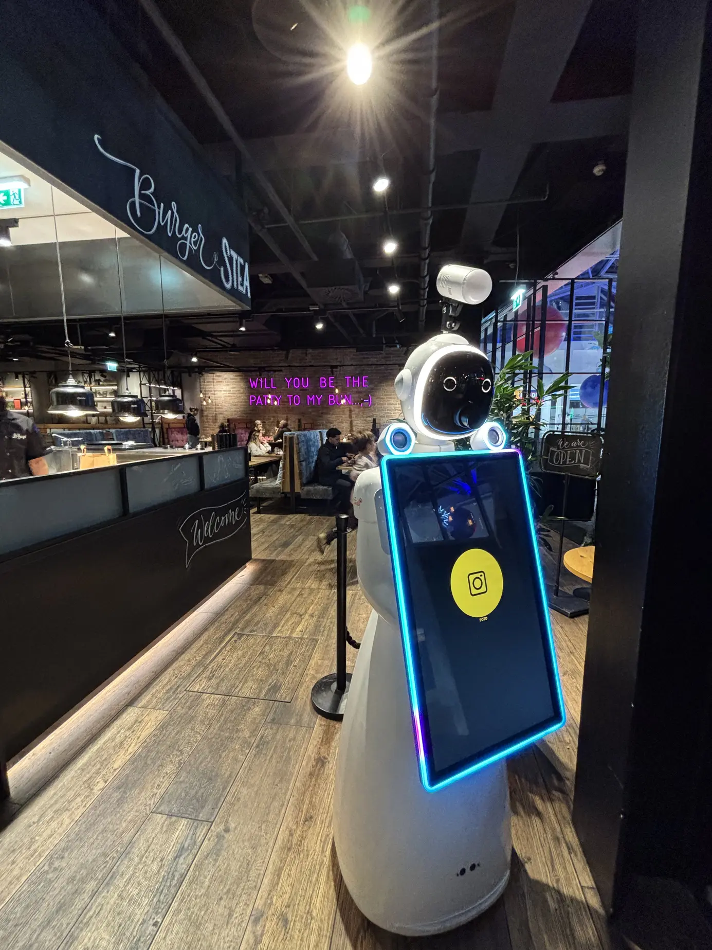 Der Roboter im Lokal unter dem Burger-und-Steak-Leuchtschriftzug