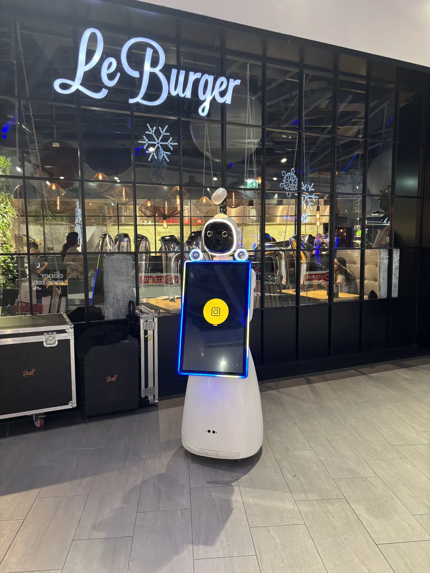 AI Fotobox Roboter LUNA vor dem beleuchteten Le-Burger-Schriftzug im Auhof Center