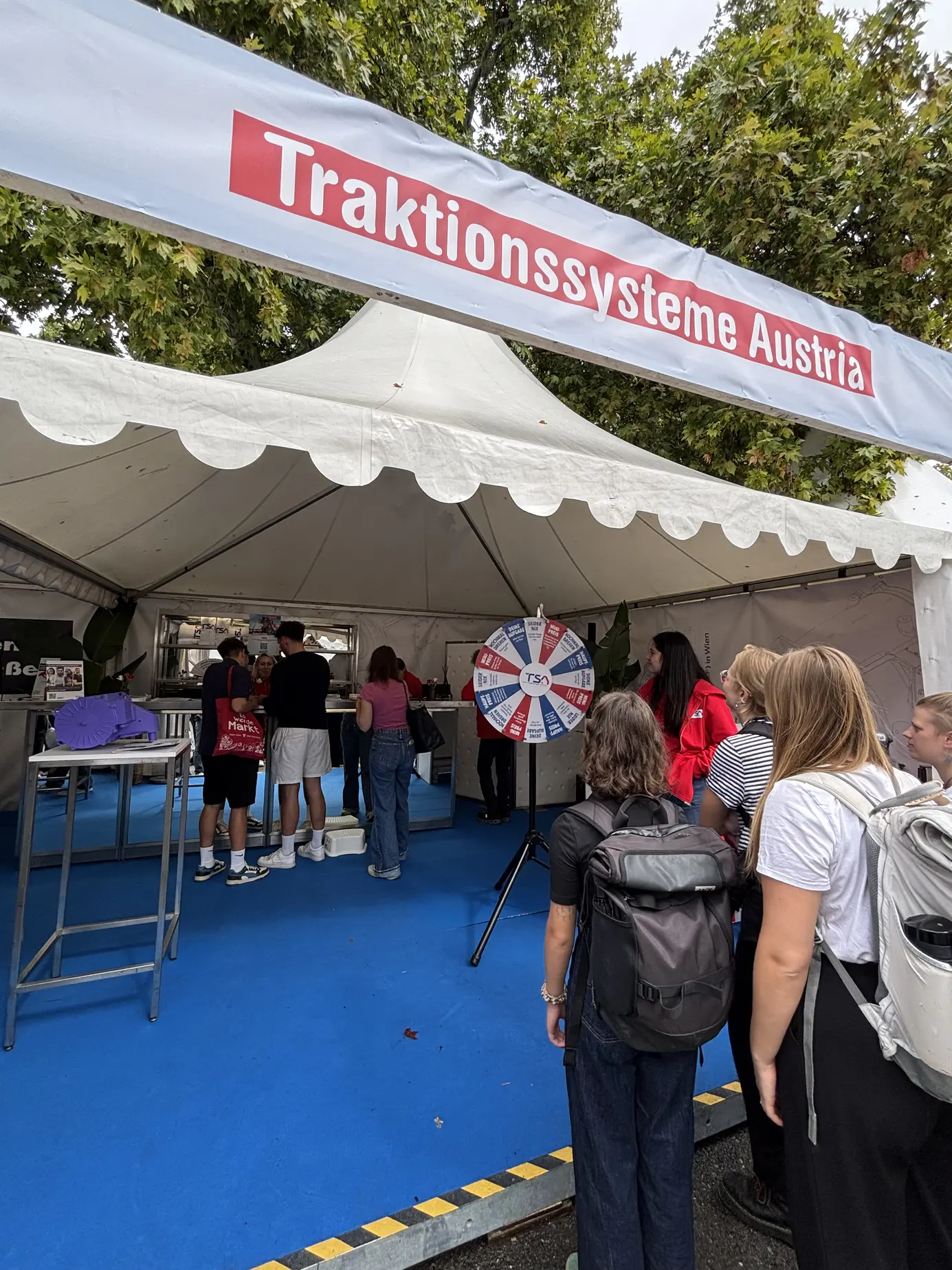 Der Stand von Traktionssysteme Austria mit Banner und Glücksrad am Rathausplatz
