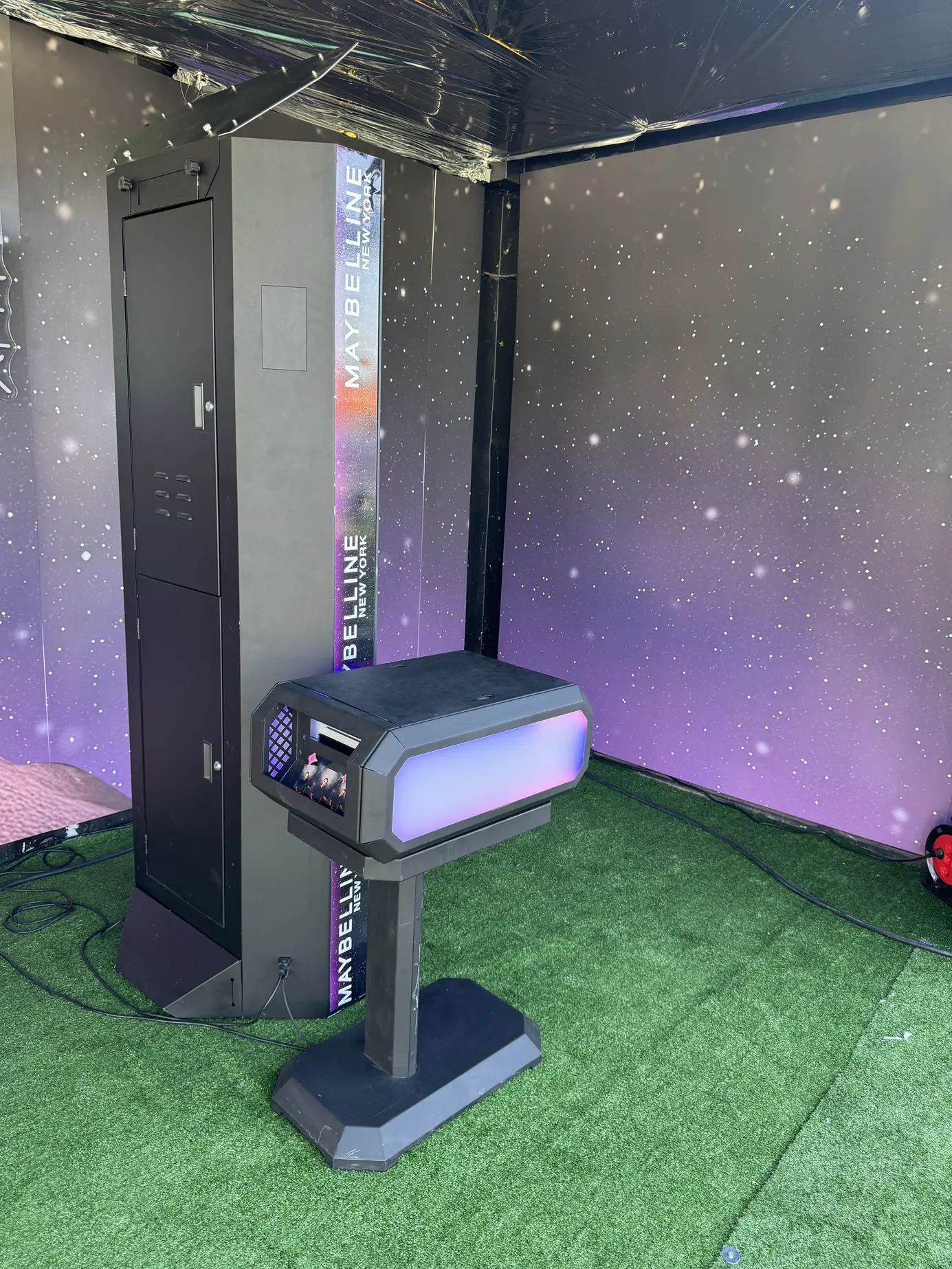 Drucksäule des Magic Mirror X mit beleuchtetem Ausgabeschacht auf Kunstrasen