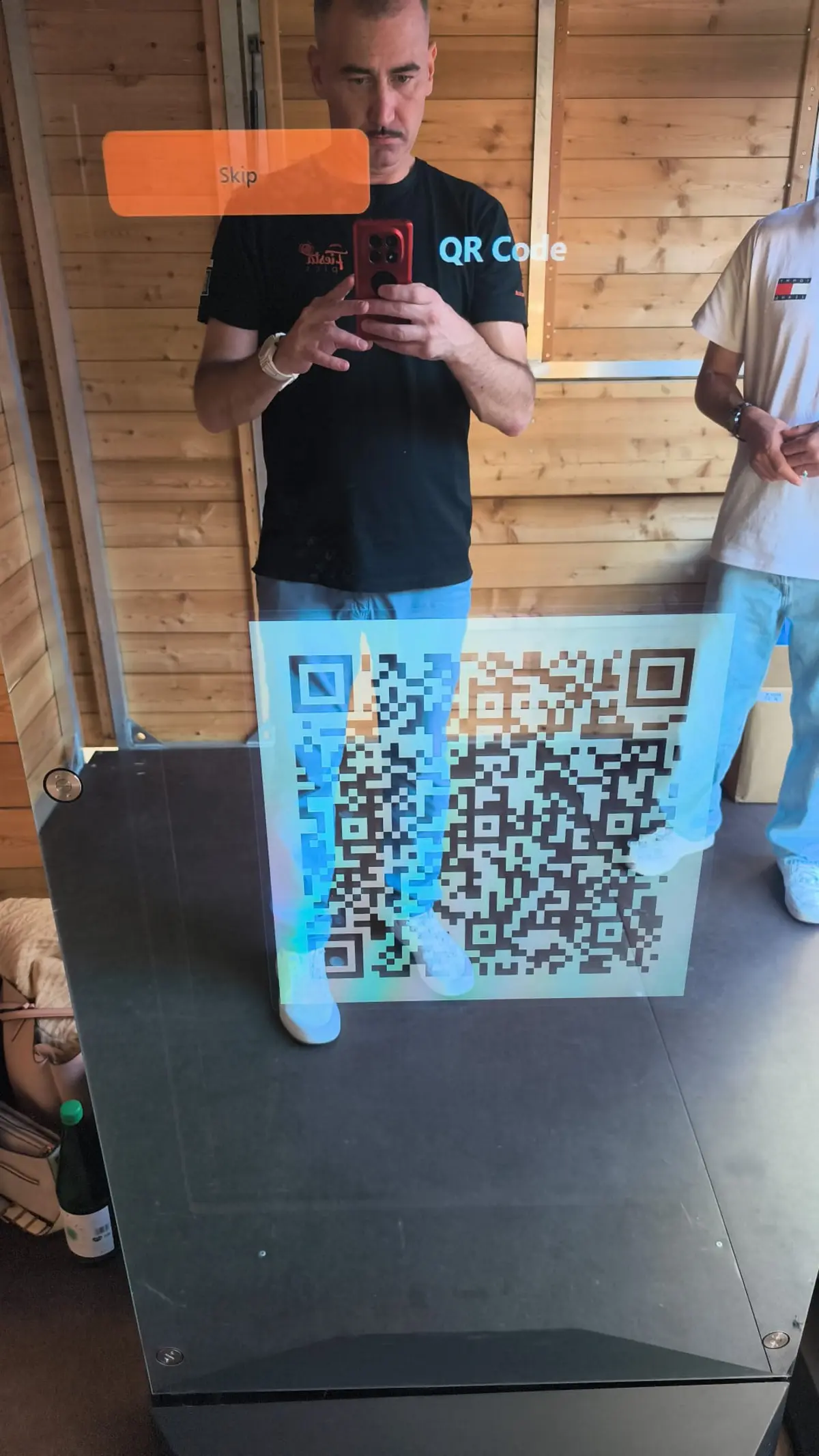 Gast scannt den QR-Code am Display des Fotospiegels