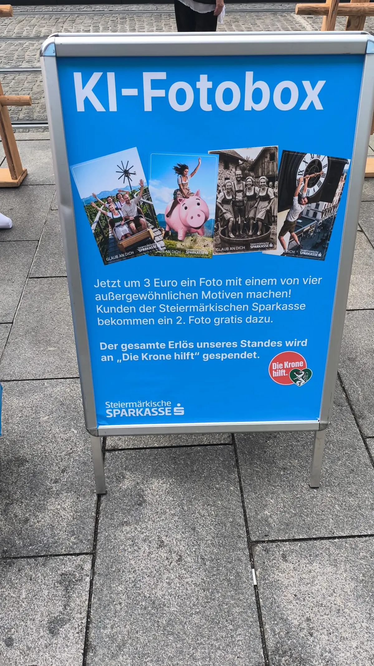 Aufsteller der KI-Fotobox mit Hinweis auf Fotogutschein und Spendenaktion