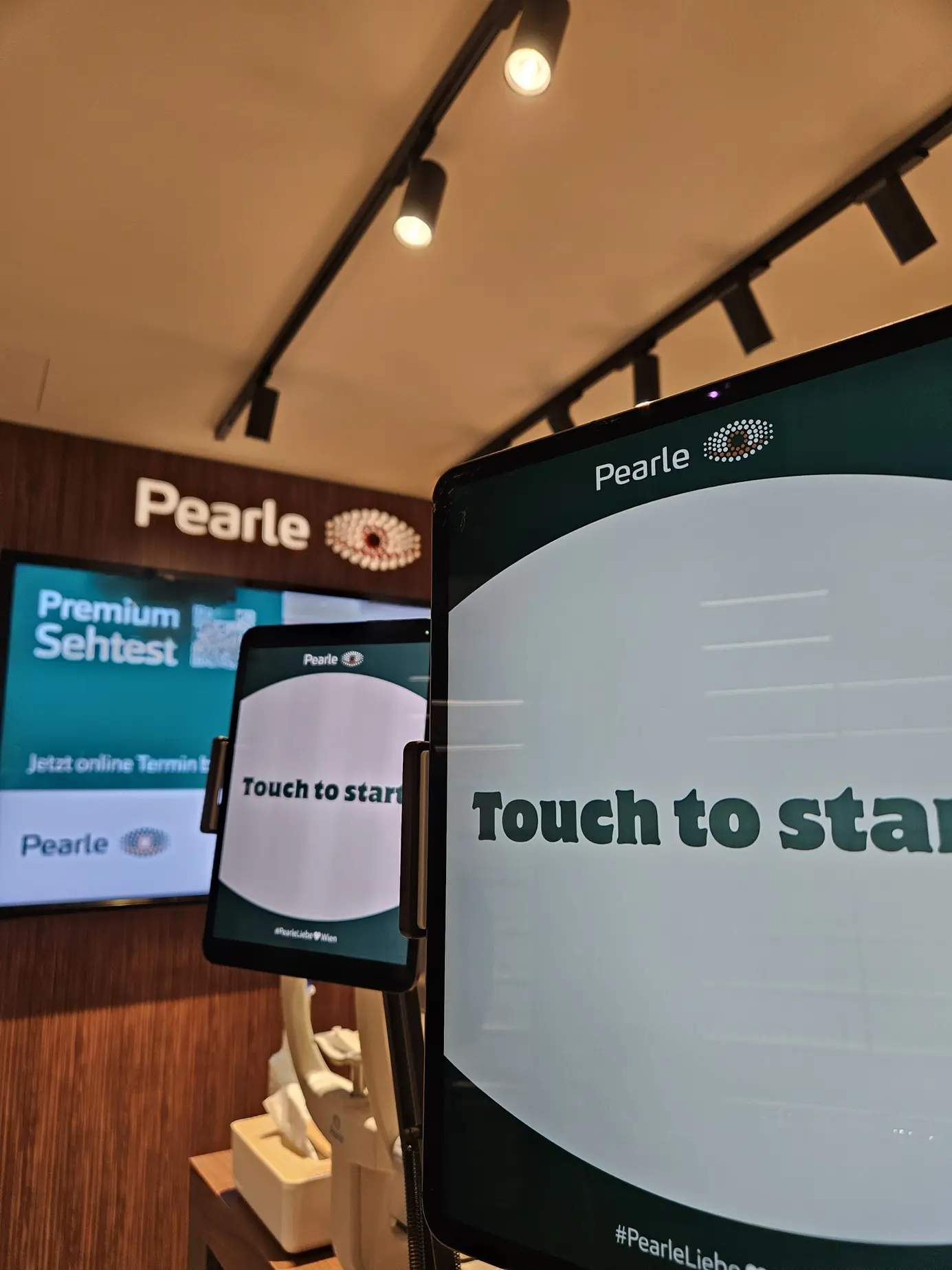 Zwei Tablets als Fotostationen mit dem Hashtag #PearleLiebe vor der Wand mit dem Pearle-Logo