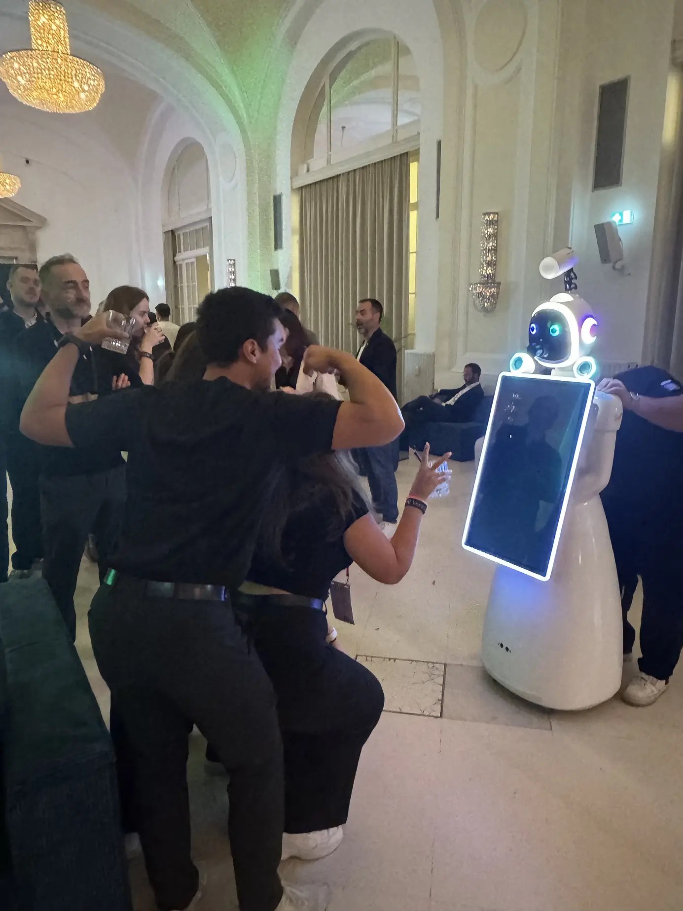 Zwei Gäste posieren vor dem KI-Roboter LUNA im Ballsaal der Hofburg