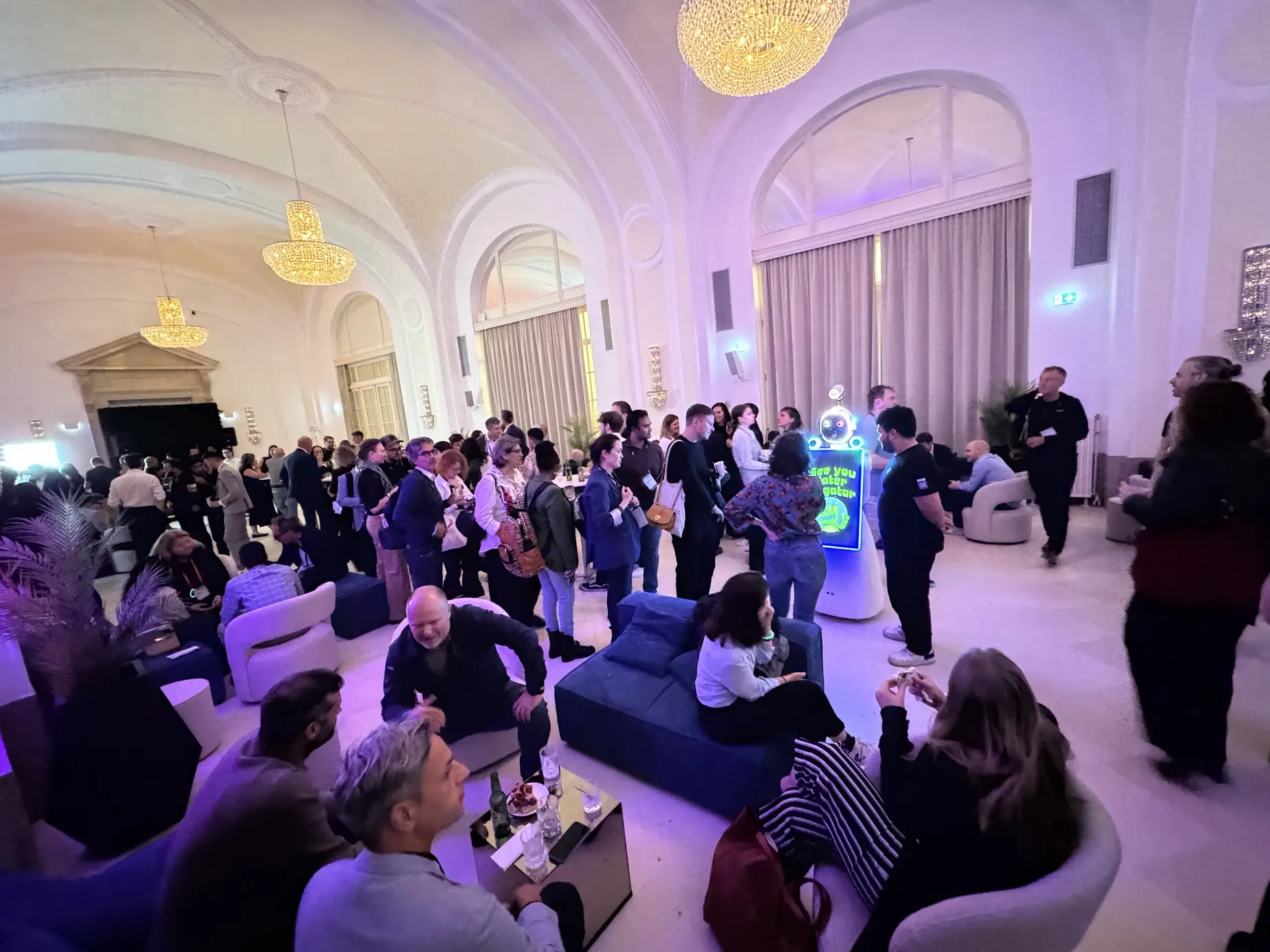 Gäste der TEDAI Vienna 2025 im Festsaal der Hofburg Wien mit dem AI Fotobox Roboter LUNA im Hintergrund