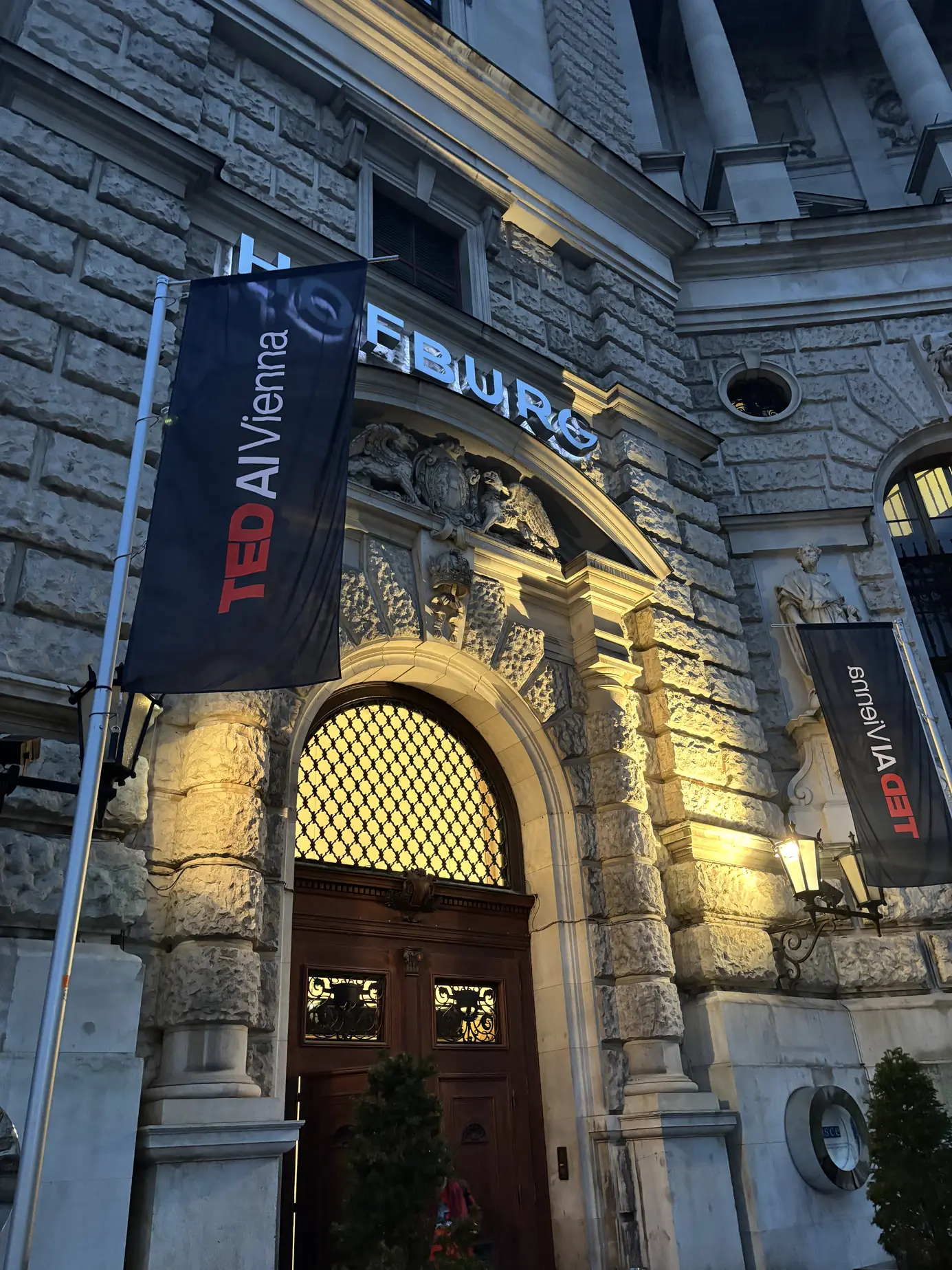 Beleuchtete Fassade der Hofburg Wien mit TEDAI-Vienna-Fahnen am Eventabend
