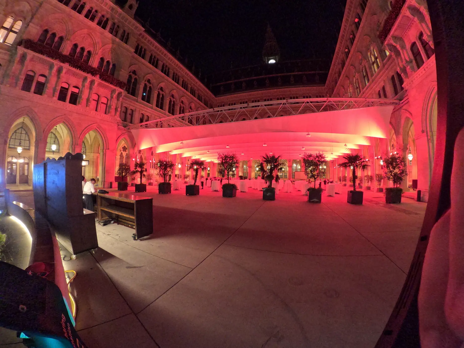 Arkadenhof des Wiener Rathauses am Abend in rotem Licht, vorne der 360° Ground Spinner von FiestaPics beim Event von BiM – Bildung im Mittelpunkt