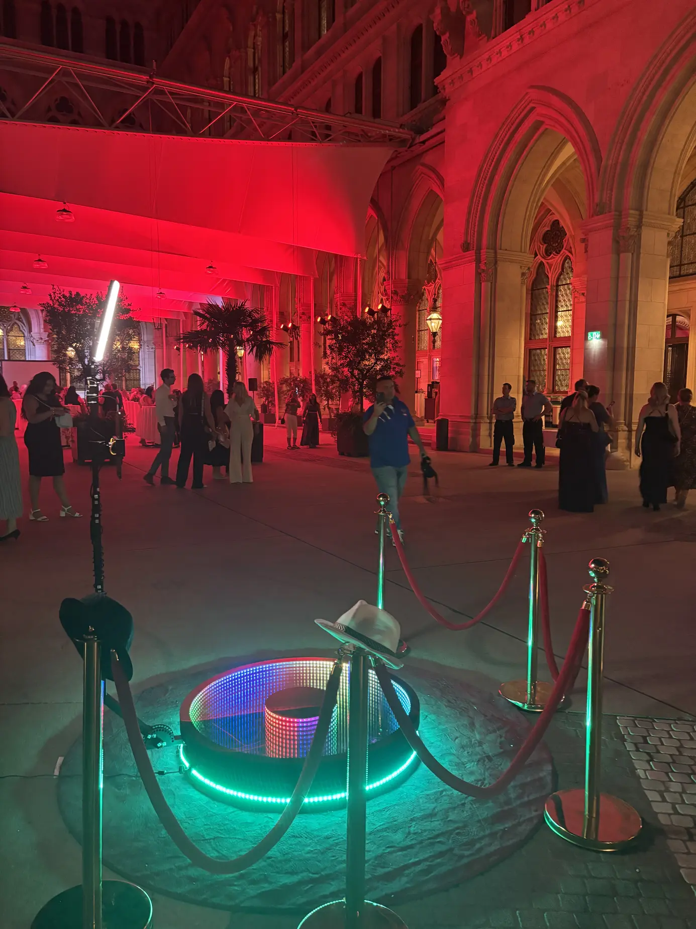 360° Ground Spinner mit grün leuchtender Plattform und Absperrkordeln unter den rot beleuchteten Arkaden