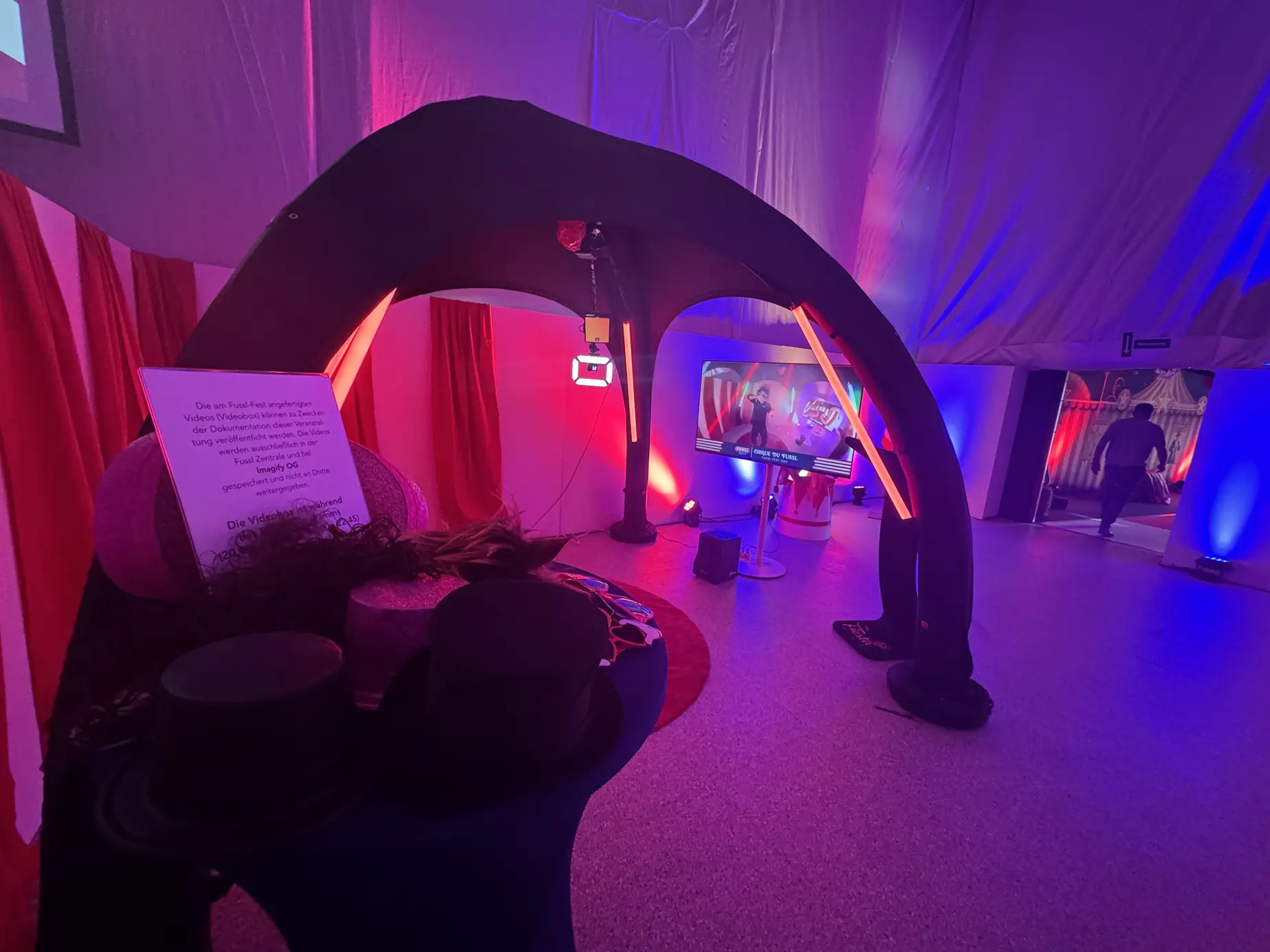 Requisitentisch mit Zylindern und Masken vor dem 360° Headspinner in pink-blauem Licht