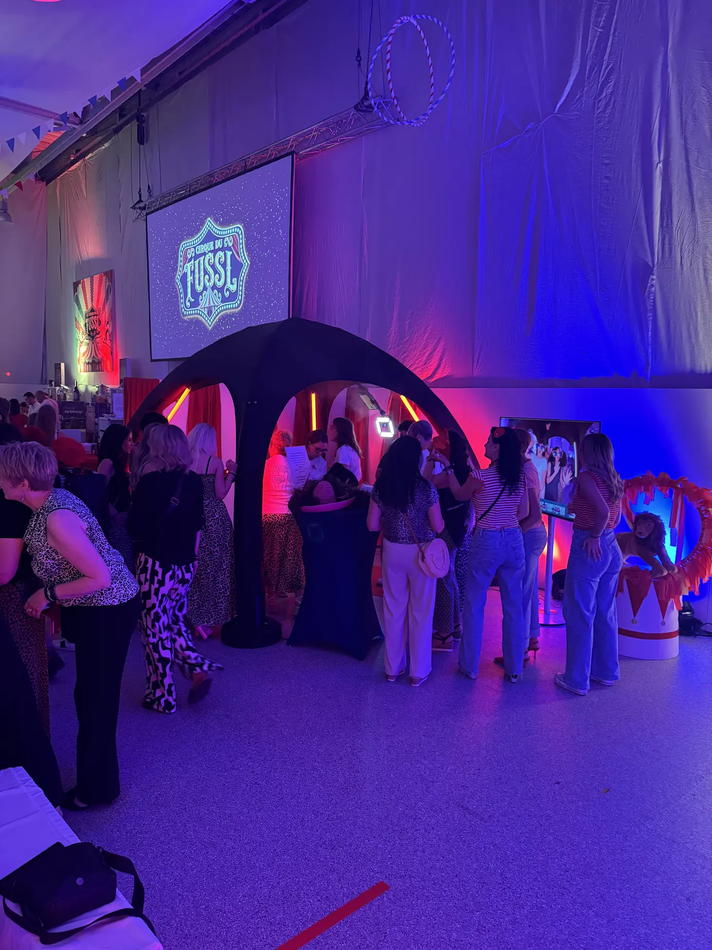Gäste stehen am Abend vor dem 360° Headspinner in der Festhalle des Fussl Fest