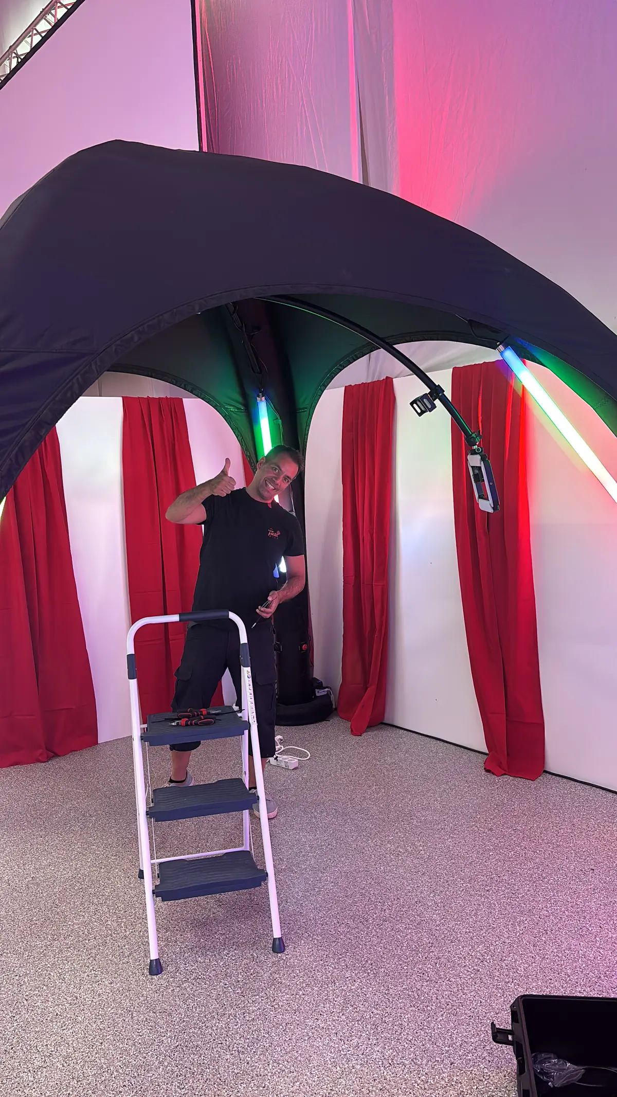 FiestaPics-Mitarbeiter beim Aufbau des 360° Headspinner vor roten Vorhängen