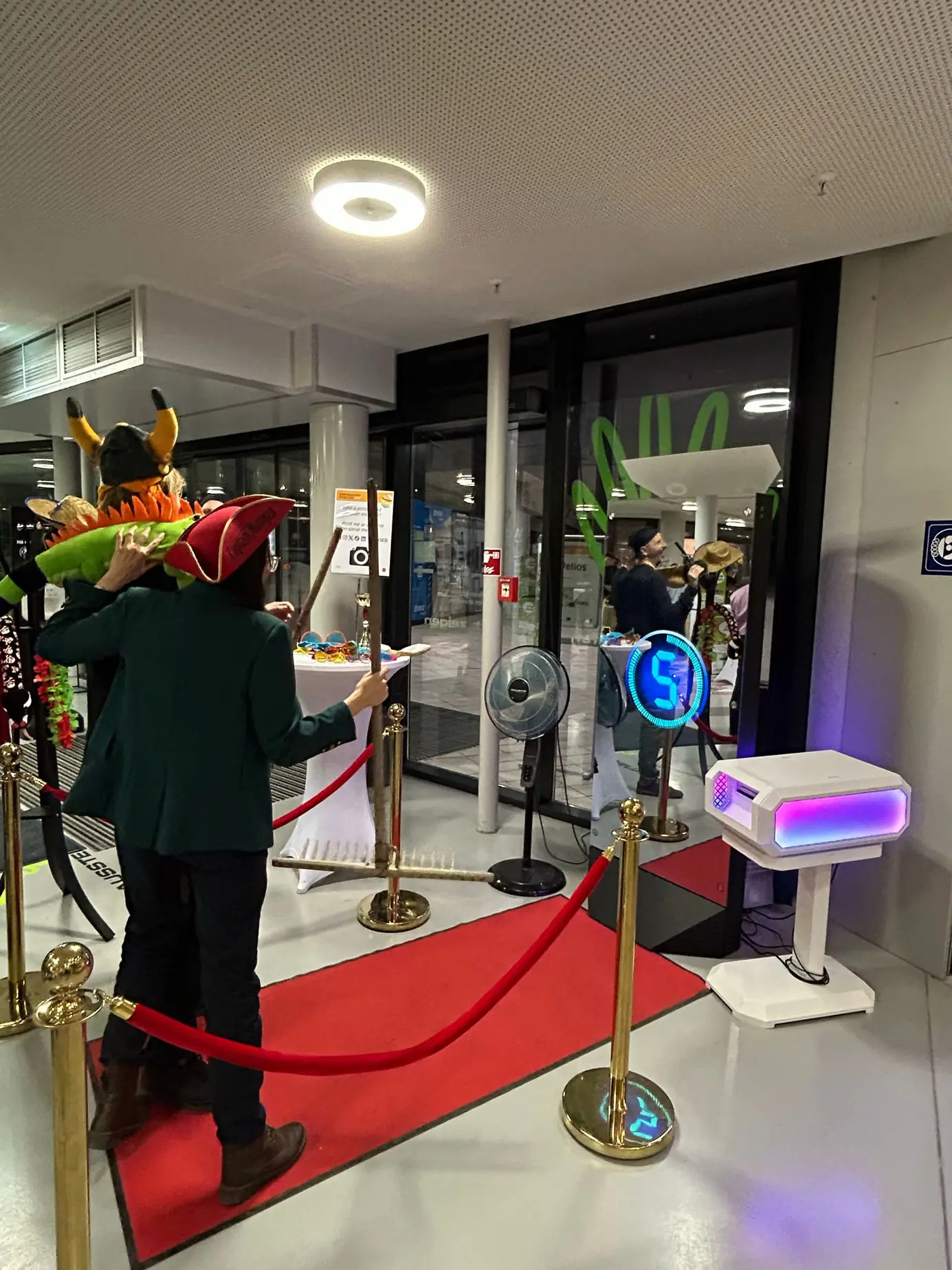 Countdown am Magic Mirror X, daneben Requisitentisch und goldene Absperrständer auf rotem Teppich
