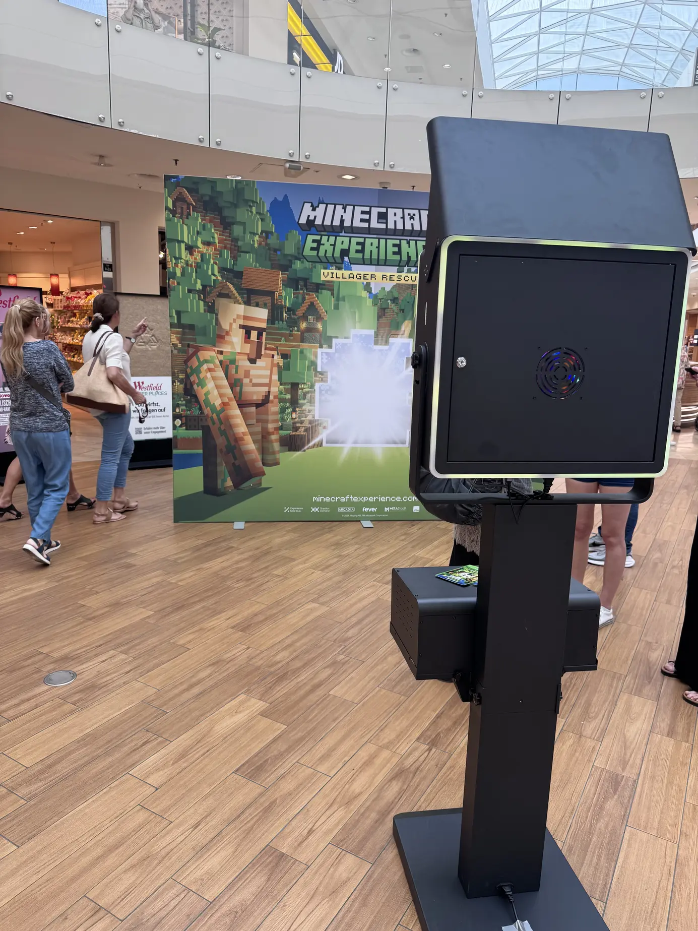 Seitenansicht der Fotobox Classic auf schwerem Standfuß vor der Minecraft-Kulisse im Shopping Center