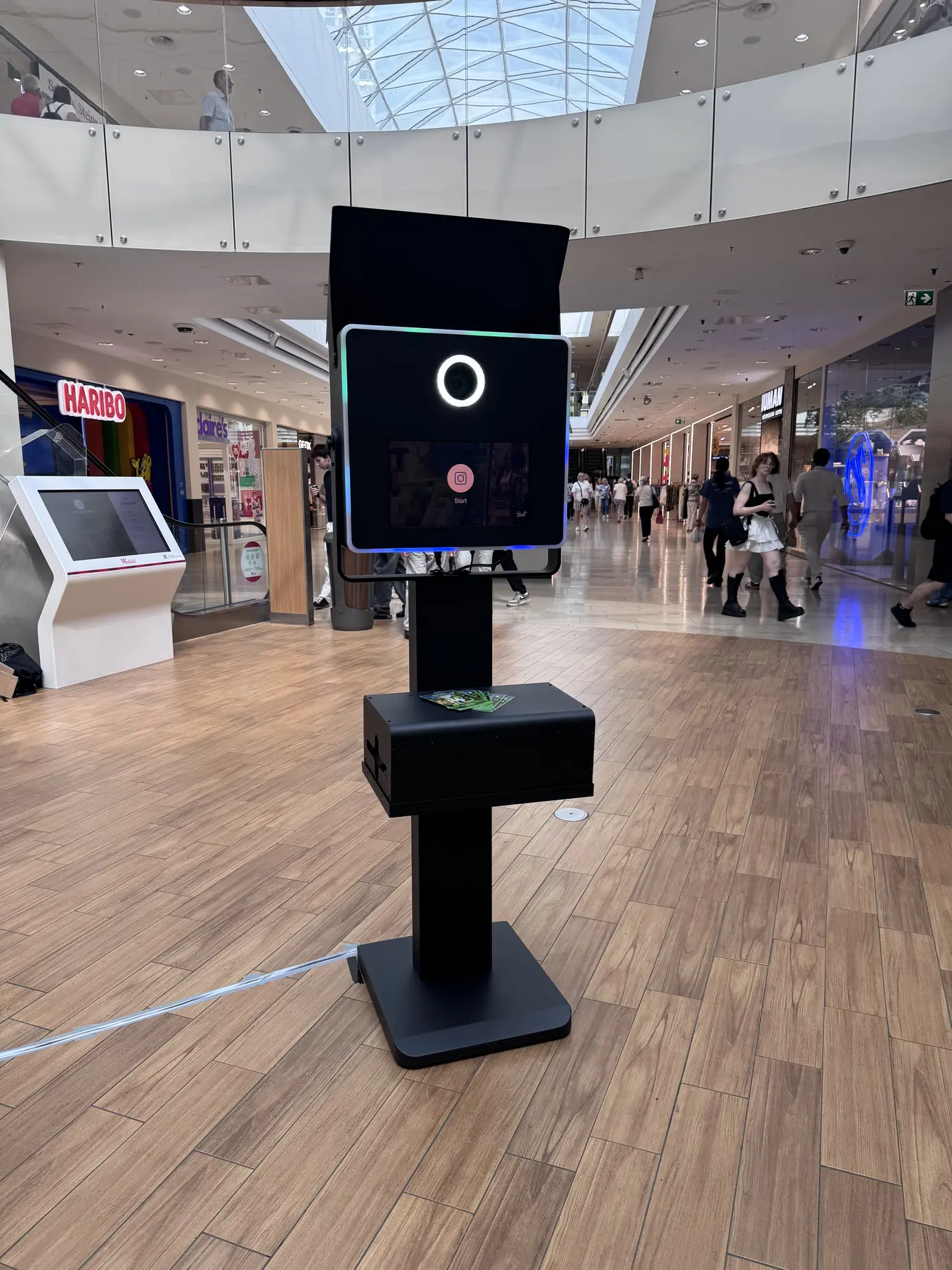 Frontansicht der Fotobox Classic mit Ringlicht und Touchscreen unter der Glaskuppel des Donau Zentrum