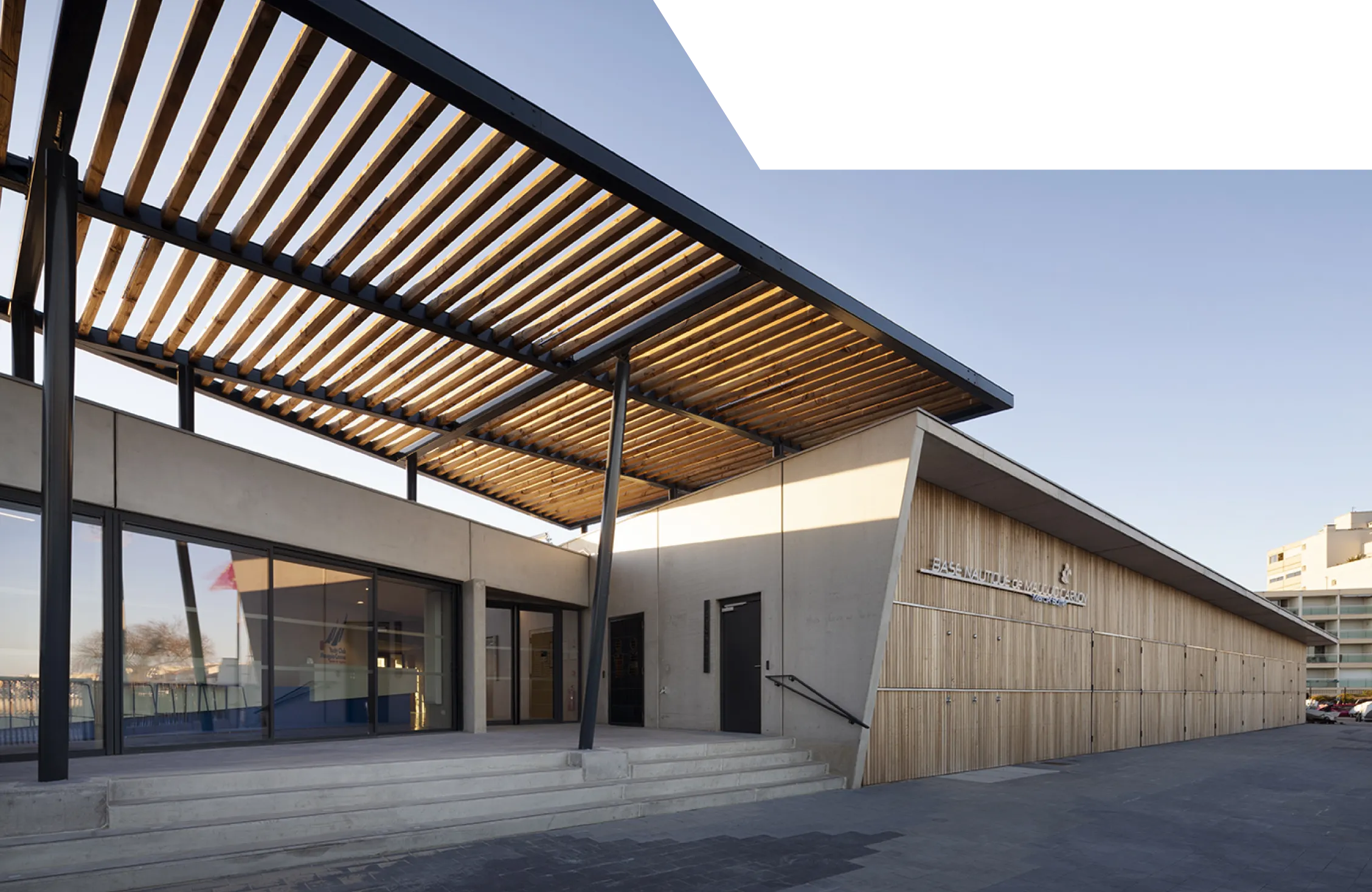 Menuiserie extérieure et bardage bois sur mesure : auvent en lattes et entrée vitrée sur structure métallique, par un menuisier agenceur à Montpellier