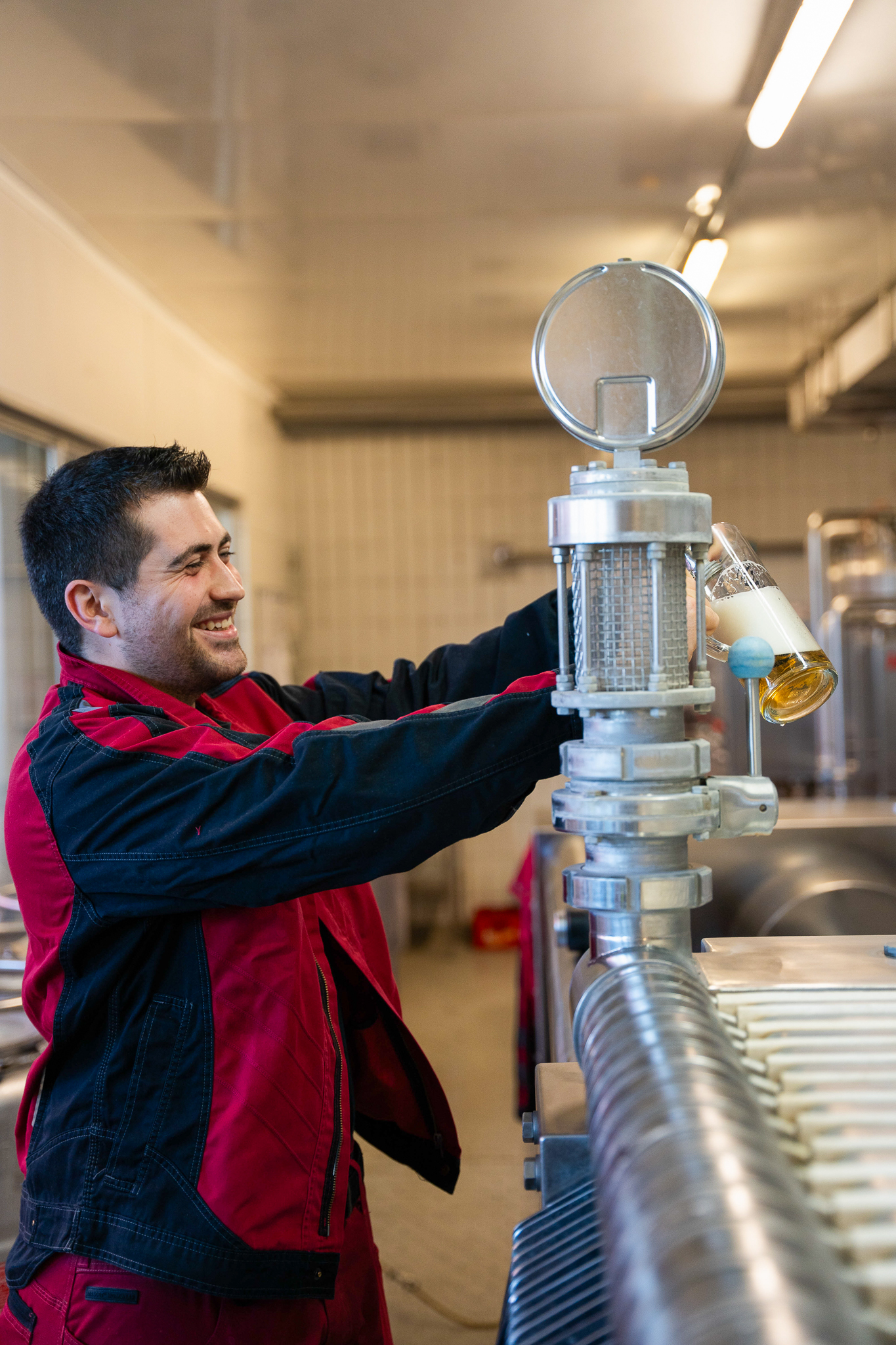 Ein Mann in Arbeitskleidung arbeitet an einer Maschine in der Brauerei.