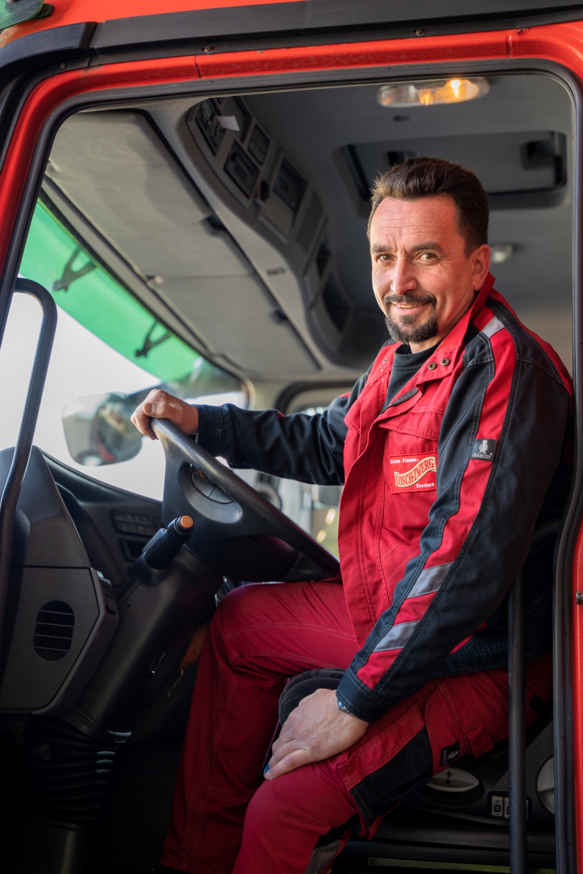Ein Mann sitzt lässig in einem LKW.